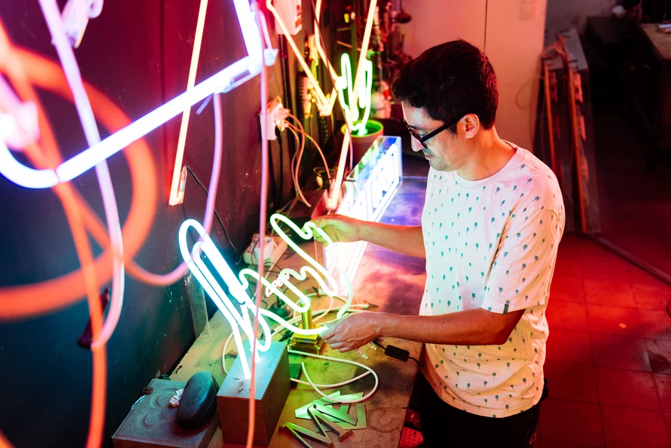 Artisan créant des enseignes lumineuses au néon dans son atelier