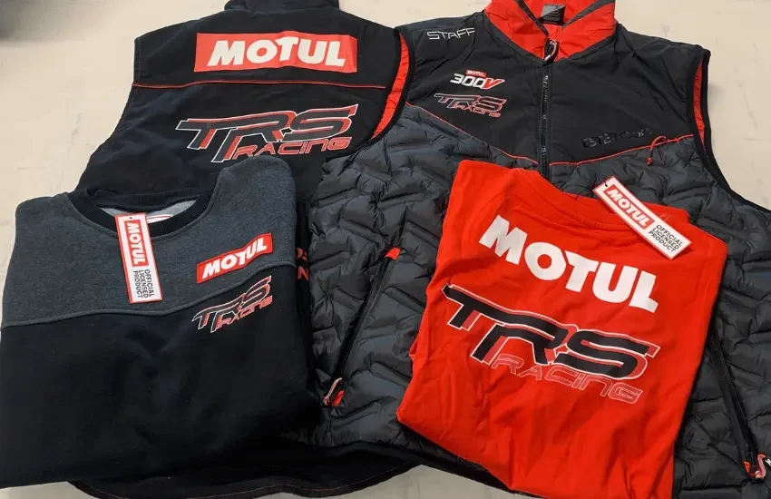 Gros plan sur un rouleau de papier ou vinyle blanc en cours de déroulement, montrant des caractères typographiques noirs partiellement visibles sur la surface